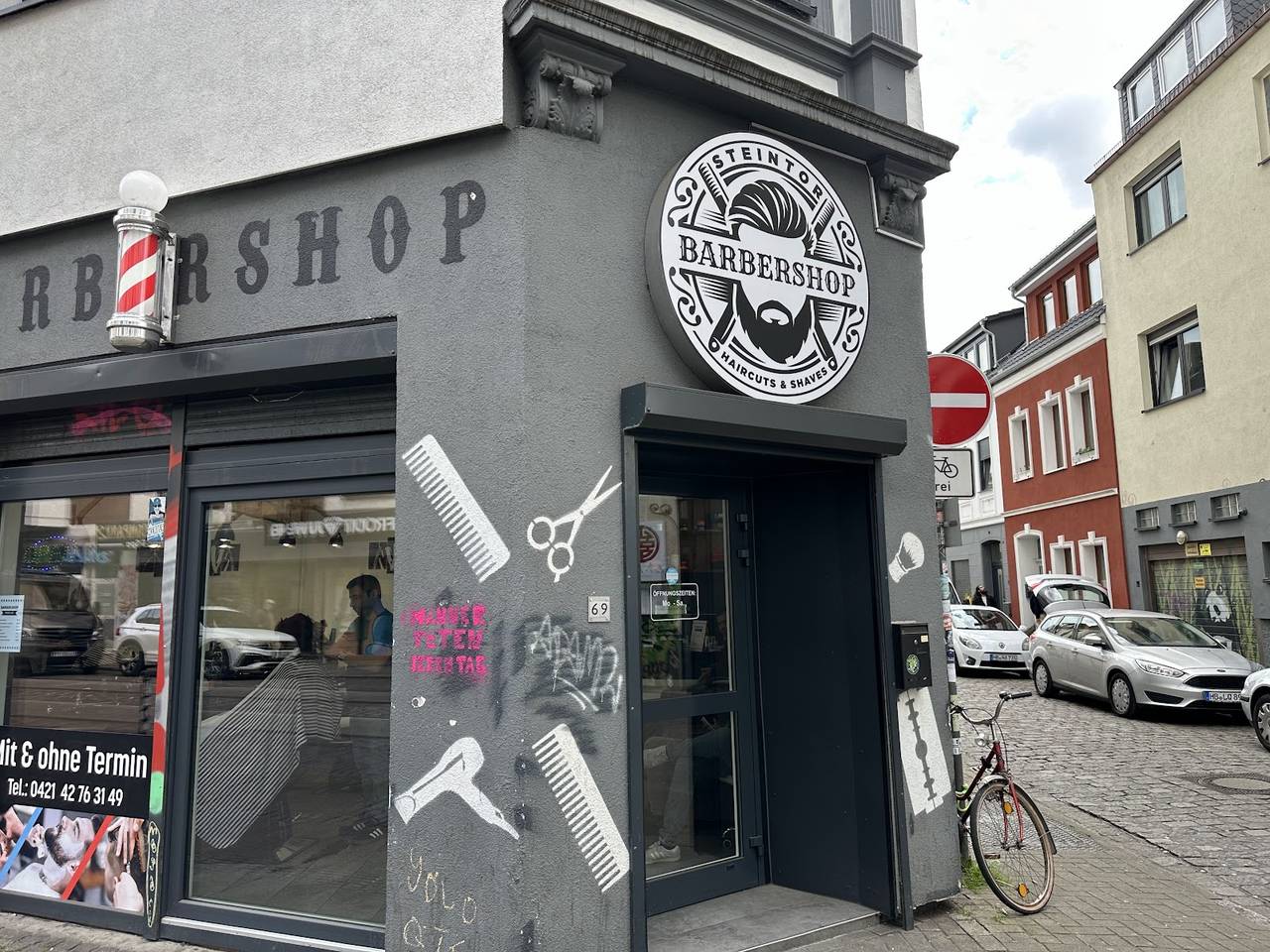 Eckladen BarbierShop, Vor dem Steintor 69: rundes Schild „Steintor Barbershop“, Barber-Säule