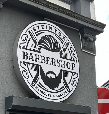 Rundes Ladenschild „Steintor Barbershop – Haircuts & Shaves“