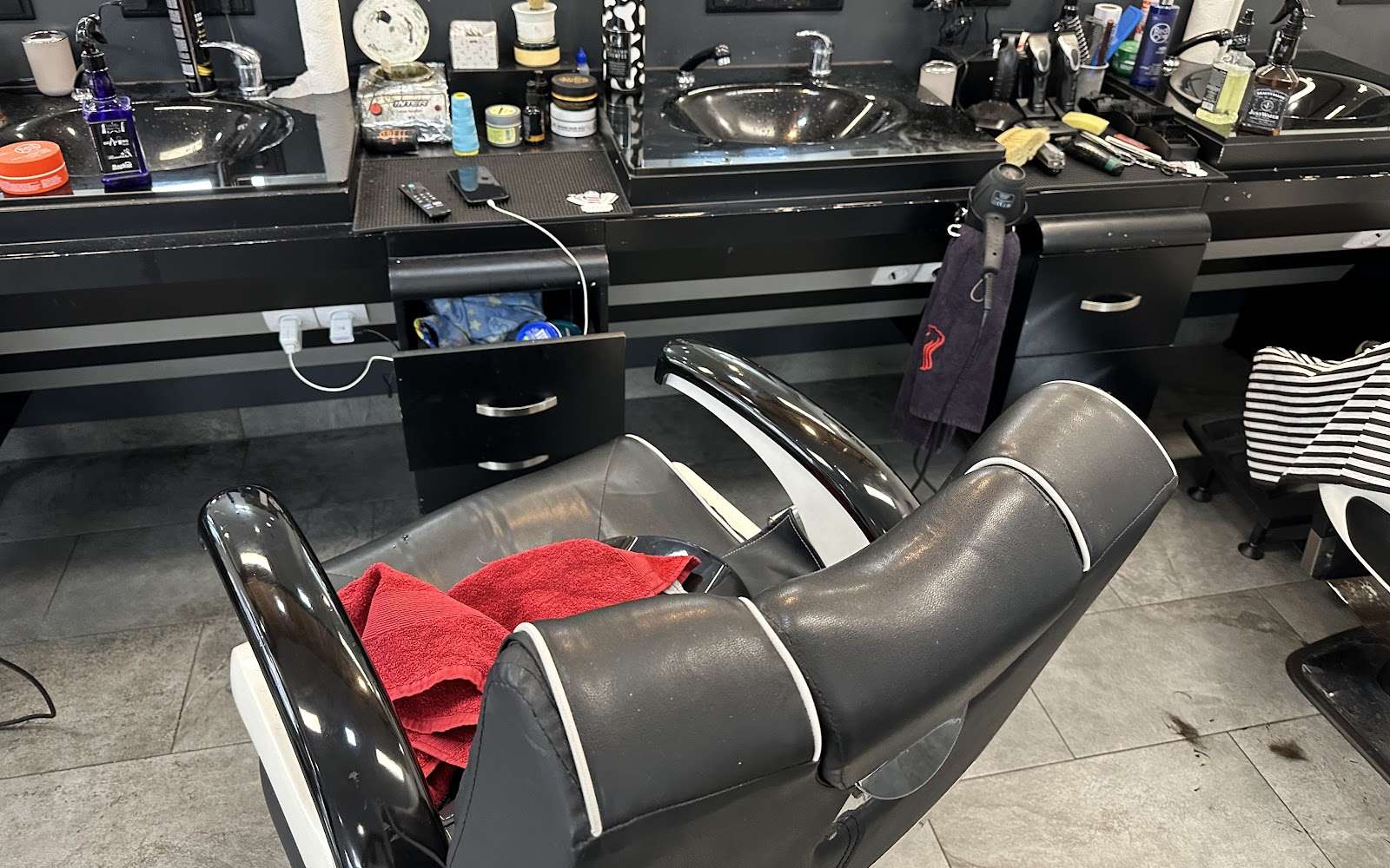 Barber-Plätze mit schwarzen Stühlen, Spiegeln und Waschbecken